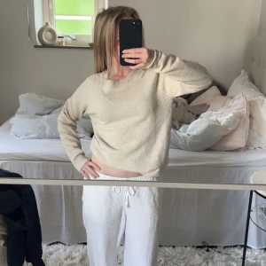 Beige stickad tröja - Mysig beige stickad tröja med rund halsringning och långa ärmar. Tröjan har en enkel och stilren design, perfekt för lager-på-lager och passar till det mesta i garderoben. (Har ett litet hål på kragen, men går att sy så den ej syns)