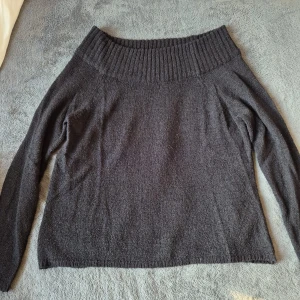 Svart stickad tröja från Amisu - Mysig svart stickad tröja från Amisu med bred ribbad krage som kan bäras offshoulder. Köpt från NewYorker. Tröjan har lång ärm och är perfekt för kyligare dagar. Enkel och stilren design som passar till mycket.