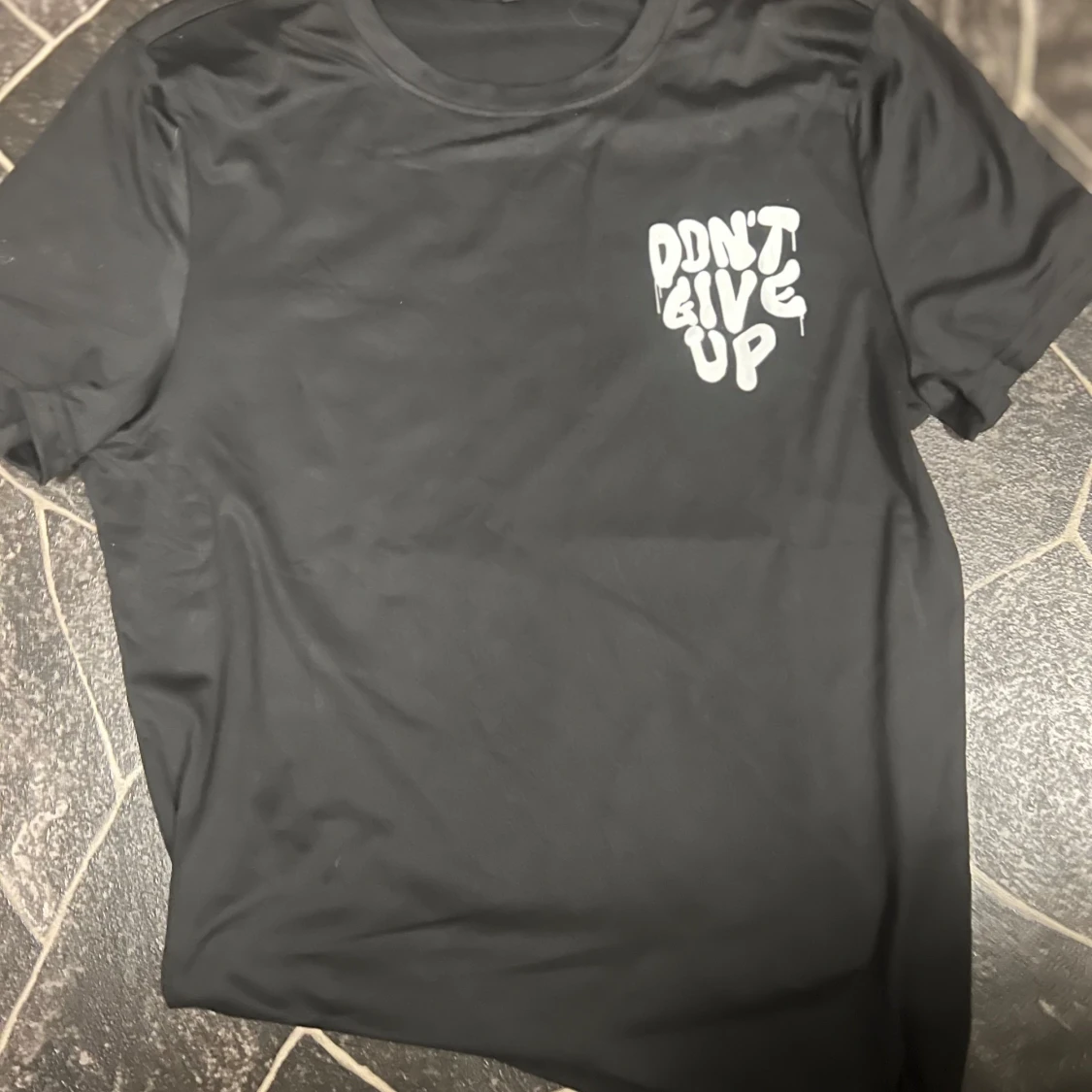 Svart t-shirt med tryck 'Don't Give Up'