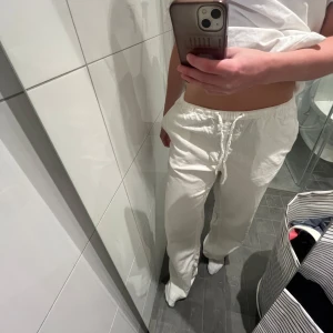 Vita linnebyxor från BikBok - Säljer ett par vita linnebyxor från BikBok i storlek XS. Modellen är ”AIR”. Jag på bilden är 166cm, och har vanligtvis S i byxor. Byxorna är dock i xs men tycker det passar en S också. Knappt använda så det finns inga defekter. Nypris är 499kr. Midja: 64-68cm. Höft: 88-92cm. Innerbenslängd: 81 cm.    