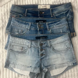 Tre par lågmidja jeansshorts  - Säljer tre par snygga jeansshorts. Ett par från Hollister med klassisk femficksdesign och två par från Tally Weijl med knappar framtill och råa kanter. 