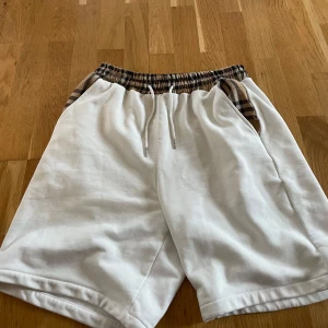 Burberry shorts - Burberry shorts med badshorts material. Finns även t shirt till denna som kan säljas som ett hel set. Fråga efter setet ifall ni är intresserade!