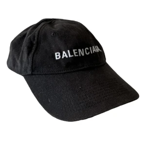 Keps Balenciaga - Svart keps från Balenciaga med klassisk böjd skärm och vit broderad logga framtill.  Kvitto ingår