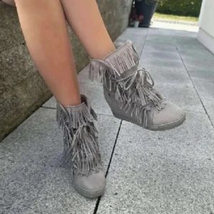 Fransskor  - Snygga grå boots i mocka med coola fransdetaljer och snörning framtill. Skorna har en diskret kilklack som ger extra höjd och en platt sula undertill. Perfekta för dig som vill sticka ut med en unik stil.