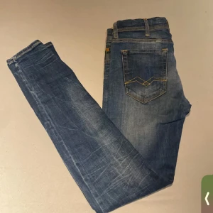 Replay blå jeans med broderade fickor - Snygga blå jeans från Replay med klassisk femficksmodell och coola broderade detaljer på bakfickorna. Jeansen har en rak passform och är tillverkade i slitstarkt denim med lätt tvättad look. Perfekta för dig som gillar en avslappnad men stilren vibe.
