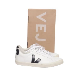 Vita Veja sneakers med svarta detaljer - Säljer mina helt nya veja skor då jag inte använder de. De är enbart använda en gång och på bilderna ser ni att de är som nya. De är i storlek 42 men passar mig bra som har 40 i mina stan smith. Va inte rädda att höra av dig vid frågor eller diskussion om pris!!