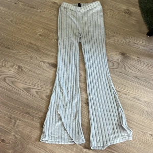 Grå ribbade vida byxor - Snygga grå ribbade byxor med vida ben och hög midja. Byxorna har ett mjukt och stretchigt material som gör dem riktigt sköna att bära. Perfekta för en chill och trendig look.