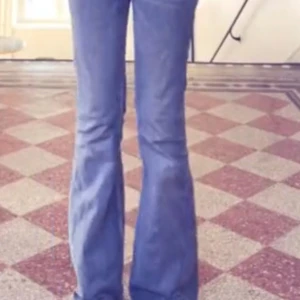 Blå bootcut jeans från weekday - Snygga blå bootcut jeans från weekday med klassisk femficksdesign och lätt slitning. Jeansen har en låg/mid midja och är tillverkade i robust denim. Perfekta för dig som gillar retrovibbar och vill ha ett par jeans med lite extra vidd nertill.