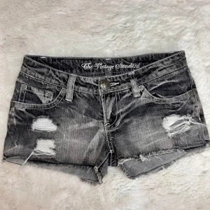 Lågmidjade jeansshorts med hål vintage gråa 2000s minishorts  - Lågmidjade jeansshorts. Står ingen storlek men uppskattar de till ungefär en w25-w26/xs.Obs: försmå för mig så har inga bilder på. Midjemått:36cm. Total längd fram på ena benet:20cm. Köp sker via köp nu, jag postar inom 24h. Kvar tills markerad såld 