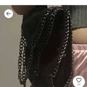 Stella McCartney liknande väska  - Säljer en svart axelväska med flera coola kedjor som axelrem. Väskan har en mjuk form och ger en edgy vibe till outfiten. Perfekt för dig som gillar detaljer och vill sticka ut lite extra.