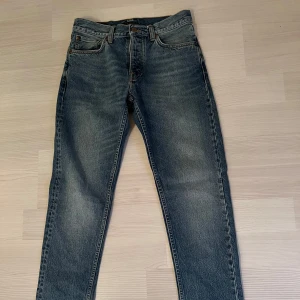 Blå jeans från Nudie Jeans - Ett par klassiska blå jeans från Nudie Jeans, riktigt bra skick använd ungefär en sommar, storlek 30/32 nypris 1600 kr mitt pris 600 kr (fler bilder vid önskemål)