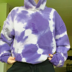 Lila tie-dye hoodie från Junkyard - Säljer en oversized hoodie från Junkyard i lila och vitt tie-dye mönster. Tröjan har huva, magficka och breda muddar vid ärmslut och nederkant. Perfekt för chill dagar och streetstyle vibes. Utgått sortiment. (Fläcken som syns på bilden är endast vatten men jag var inte tålmodig nog att låta det torka innan jag tog bilder)