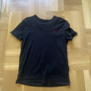 Svart Ralph Lauren T-shirt - Svart T-shirt från Ralph Lauren. Ganska väl använd men den är som ny när man väl har på den. Skriv ifall ni ok ha någon extra bild eller om ni undrar nåt!