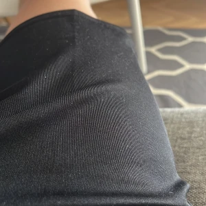 Svarta shorts i syntetmaterial - Svarta shorts i ett slätt och stretchigt syntetmaterial. De har en enkel och stilren design utan synliga detaljer eller mönster. Perfekta för dig som gillar en clean och sportig look.