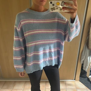 Randig oversized tröja från Stradivarius - Supermysig stickad tröja från Stradivarius i oversized modell. Tröjan är ljusblå med breda ränder i vitt och ljusrosa