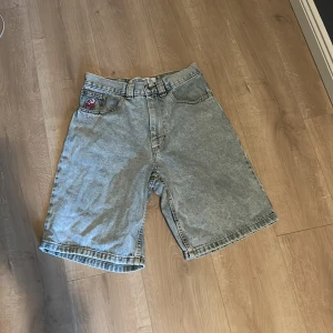 Bigboy ljusblå jeansshorts XS - Säljer ett par ljusblå jeansshorts från Bigboy i storlek XS. De har en loose passform, klassiska fem fickor och ett broderat motiv på myntfickan. Perfekta för sommaren med sin sköna denimkänsla och höga midja.