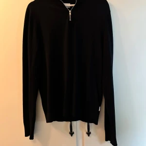 Svart half zip tröja från Lindbergh - Svart långärmad tröja från Lindbergh med half zip-dragkedja framtill. Tillverkad i mjukt material för en bekväm känsla. Endast använd ett fåtal gånger, inga anmärkningar på användning.