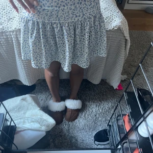 Blommig kortkjol i blått och vitt - Supersöt kortkjol med blått blommönster på vit botten. Passar s också!