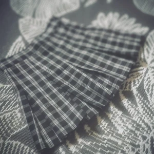 Svartvit rutig plisserad kortkjol - Supersnygg svartvit rutig kortkjol med plisserad design. Kjolen har klassiskt rutmönster och sitter högt i midjan. Perfekt för dig som gillar en preppy eller edgy stil. Lätt att matcha med både hoodies och crop tops.