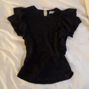 Svart blus med volangärmar - Svart topp/blus i fint skick från Lindex. Är i spets med mer unika ärmar.