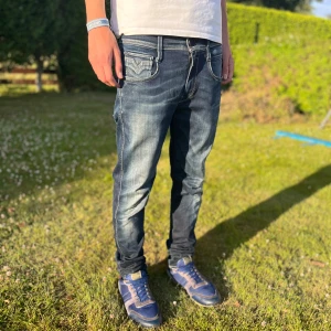 👖 Snygga Replay Anbass Hyperflex Jeans 👖 -   👖 Snygga Replay Anbass Hyperflex Jeans 👖  *   Färg: Mörkblå tvätt 💙 *   Detaljer: Klassiska kontrastsömmar och coola detaljer på bakfickorna ✨ *   Passform: Slim fit med smala ben 👌 *   Material: Slitstarkt och stretchigt bomullsjeans 🧵 *   Komfort: Riktigt sköna och stretchiga! 😌  Perfekta för dig som älskar stilrena och tidlösa jeans. 💯 Tveka inte att höra av dig om du har några frågor! 😉
