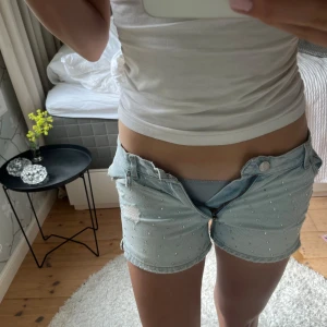 Ljusblå jeansshorts med pärlor Gina Tricot -  Ljusblå jeansshorts från Gina Tricot, med paljetter fram till, och slitningar. Säljer dessa för att dom är för små. De är i storlek 152 men skulle säga att dom passar XXS/XS💕