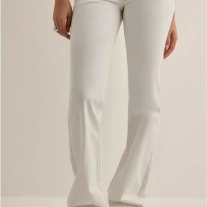 Vita bootcut jeans med kontrastsömmar - Vita jeans med bootcut-modell från Nellyoch coola kontrastsömmar på bakfickorna. Byxorna är låg midja och är tillverkade i ett stretchigt bomullsmaterial som sitter skönt. Köpte de för 699kr för runt 2 månader sedan. Säljer de då jag inte gillar hur de sitter på mig. Haft på mig de 2-3 gånger. Nytt pris: 450kr 