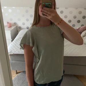Ljusgrön blus med volangärm - Supersöt ljusgrön blus med volangärmar och rundad hals med liten rynkdetalj. 💞säljer för att det inte kommer till användning🩷