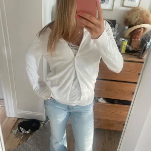 Vit kofta i bomull med knappar - Säljer en fräsch vit kofta med knappar framtill. Koftan är i mjuk bomull och  har långärmad passform. Perfekt att slänga över ett linne eller t-shirt för en chill look. Pris kan diskuteras!