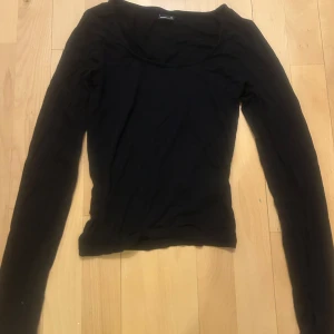 Svart soft touch top - En svart långärmad topp från Gina Tricot med rundad halsringning. Modellen är slim och sitter snyggt mot kroppen. 