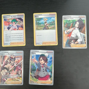 Pokémon Trainer Supporter Cards (5-pack)  - Samling med 5 coola Pokémon Trainer-kort: Roseanne's Backup, Barry, Cheren's Care, Single Strike Style Mustard och Gloria. Perfekt för dig som vill boosta din samling eller spela med snygga supporter-kort. Färgstarka illustrationer och populära karaktärer från Pokémon-världen.