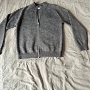 Sandö kofta  - Grå stickad Sandö kofta med dragkedja, använd endast två gånger, storlek L. Inga skador, som ny och väldigt mjuk. Som helt ny. 