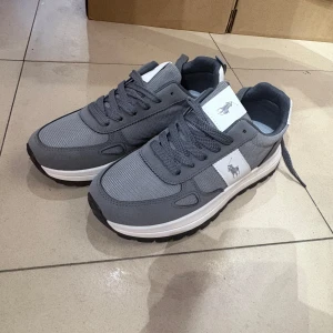 Grå sneakers från Polo Ralph Lauren - Snygga grå sneakers från Polo Ralph Lauren med vit logga på sidan och tungan. Ovandel i mesh och syntet, vit och svart sula med bra grepp. Klassisk rund tå och snörning för perfekt passform. Perfekta för en stilren och sportig look.