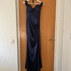 Marinblå satinklänning med paljetter💙 - Elegant satinklänning, storlek M/38. Endast använd en gång, i perfekt skick utan fläckar eller defekter. 95 % polyester, 5 % elastan – sitter perfekt som den ska på kroppen. 💙
