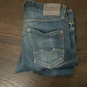 Blå Replay jeans med klassisk tvätt - Säljer ett par blå jeans från Replay med klassisk tvätt och snygga detaljer på bakfickan. Jeansen har en normal passform och är tillverkade i slitstarkt denim. Perfekta för dig som gillar en tidlös och avslappnad stil.