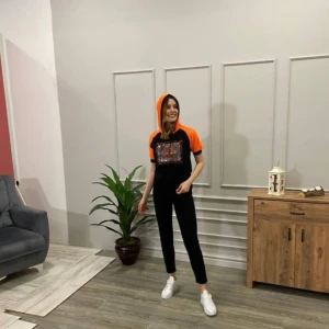 Svart och orange hoodie från Karens med svarta byxor - Cool hoodie från Karens i svart med orange detaljer och huva. Framsidan har ett stort tryck med texten 'Los Angeles' i orange. Tröjan har korta ärmar och sportig mesh vid huvan och axlarna. Perfekt för dig som gillar streetstyle och vill sticka ut😌🧡