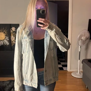 Ljusblå jeansjacka från BikBok XS - Säljer en oversized ljusblå jeansjacka från BikBok i storlek XS. Jackan har klassiska bröstfickor med knappar, slitna detaljer och en avslappnad passform. Perfekt att slänga över en hoodie eller crop top för en chill look.