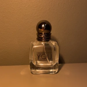 Emporio Armani Stronger With You parfym - Emporio Armani Stronger With You är en stilren parfym i en genomskinlig glasflaska med rundad form och metallisk, mörkgrå kork. Flaskan har tydlig logga och elegant design, perfekt för dig som gillar exklusiva dofter och snygga detaljer. helt tom.