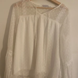 Vit blus  - Så söt blus ifrån VILA. Helt ny och är bara provad. Säljer pågrund av fel storlek! Långärmad med fina detaljer och snören upptill. Säljs för 150kr!!💝