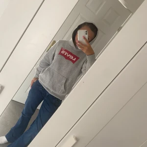 Grå Levi's hoodie  - Säljer en grå hoodie från Levi's med stor röd logga på bröstet. Tröjan har inga hål eller fläckar men lite miss färg på insidan av huvan säljer den för den är för liten 