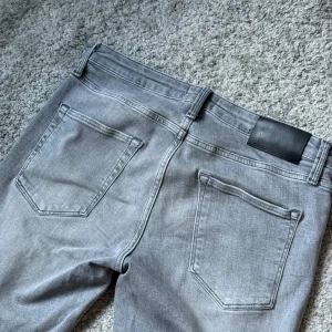 Jack&Jones Jeans - Snygga grå jeans från Jack & Jones i klassisk femficksmodell. Storlek 30x32, och modell regular/clark. Perfekta för dig som gillar en stilren och enkel look. Materialet är mjukt och skönt denim. Pris kan diskuteras vid snabb affär! 