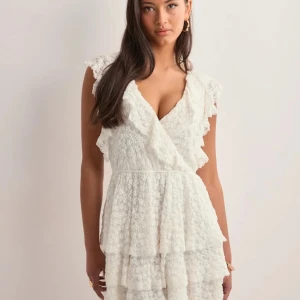 Vit omlottklänning med volanger - Supersöt vit, kort klänning som ej kommer till användning längre🫶🏻 den är slutsåld på nellys hemsida🫶🏻 utmärkt till skolavslutning, midsommar, dejt med fine shyt eller egentligen vad som helst🫶🏻 nypris=599kr