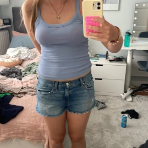 Ljusblå ribbad linnetopp Gina Tricot XS - Supersöt ljusblå ribbad linnetopp från Gina Tricot, basically basics-kollektionen. Topp med smala axelband och tight passform, perfekt till jeansshorts eller kjol. Enkel och stilren design som är lätt att matcha.