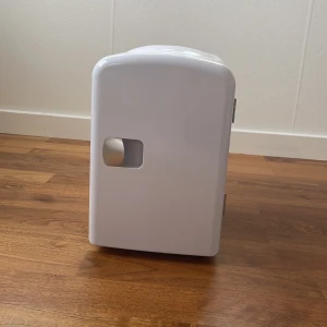 Fint mini kylskåp!💞 - Snyggt och kompakt sminkkylskåp i vit plast med blå insida. Perfekt för att förvara dina hudvårdsprodukter och smink så de håller sig fräscha längre. Har hylla för extra förvaring och kan både kyla och värma. Passar perfekt på sminkbordet.