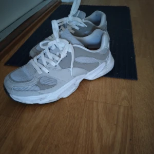 Vita chunky sneakers med meshdetaljer - Snygga chunky sneakers i vitt med gråa inslag och meshdetaljer för extra andningsförmåga.  vadderade kanter vid hälen