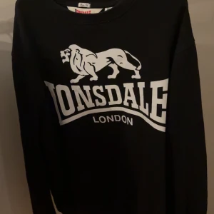 Svart Lonsdale sweatshirt  - Svart sweatshirt från Lonsdale London i slim fit-modell. Passar mer åt S hållet än M. Priset är ej hugget i sten.