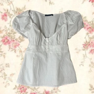 Vit blus med puffärm och knappar - Supersöt topp från Brandy Melville 🫶🏻aldrig använd! Köpt i Miami! Den passar tyvärr inte och det är därför jag säljer den!💕💕