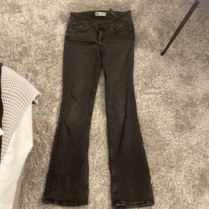 Svarta bootcut jeans från Zara - Säljer ett par svarta jeans från Zara med bootcut-modell och låg midja. Jeansen har klassisk femficksdesign och är tillverkade i stretchig bomullsdenim för en bekväm passform. Perfekta till sneakers eller boots.