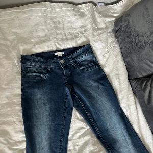 Mörkblåa bootcut jeans  - Ett par helt oanvända low rosé bootcut jeans från Gina tricot i storlek s. Men från Gina Youngs kollektion så är därför mindre i storleken än vuxen storleken s.