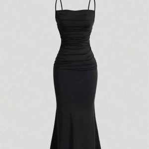 Svart långklänning med smala axelband - Snygg svart långklänning med smala axelband och figurnära passform. Klänningen har rynkade detaljer framtill och en mjukt utsvängd nederdel. Klänningen har endast används en gång för bilder. Klänningen är 134 cm. 